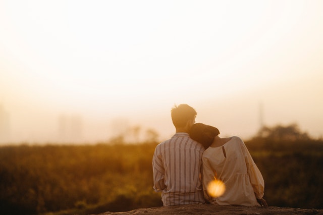 couple facing sunset outdoors