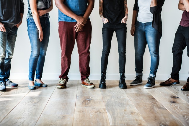 group of young adults standing indoors on hardwood floor