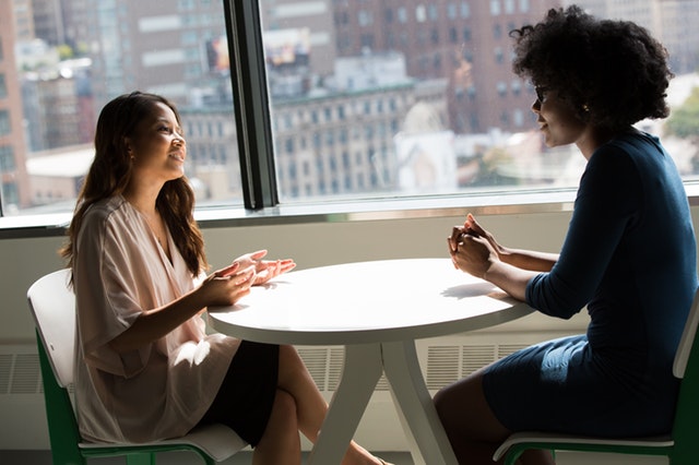 Two women having a meeting by a window