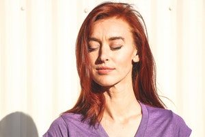 stock image of woman standing outside getting sun