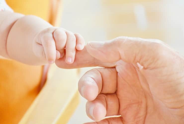 dad holding baby's hand