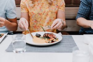 Stock image of woman eating food around friends