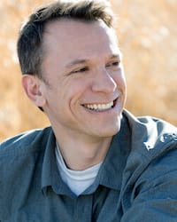 John Sander headshot outdoors in a field wearing a polo shirt