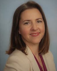 Karen Mikolic's professional headshot indoors wearing a tan top