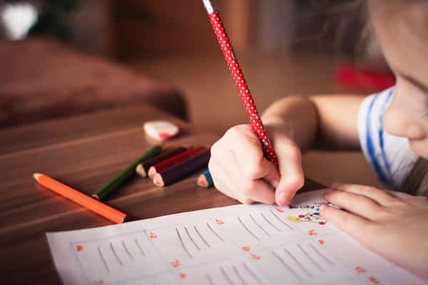 close up of young girl writing on paper