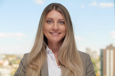 Laira Cowper's headshot in front of the Denver skyline