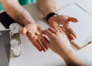 person selecting one of two pills