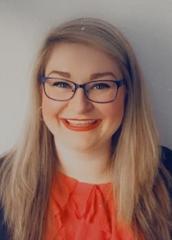 Gabby Shinagle Headshot wearing an orange top indoors