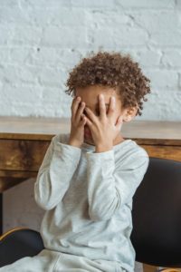 anxious kid with hands on face