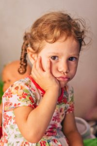 girl sitting with hand on face