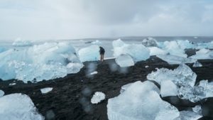 man standing in cold glaciers