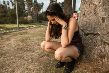 Woman anxious outside by tree