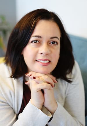 Therapist Bella Ouknine headshot wearing a beige sweater indoors
