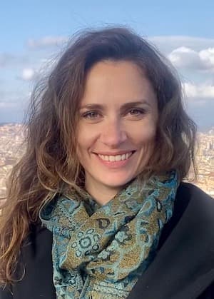 Kate Christman headshot outdoors wearing a green scarf